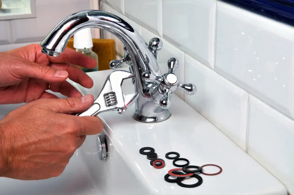 Plumber performing maintenance on a bathroom faucet in Bartow