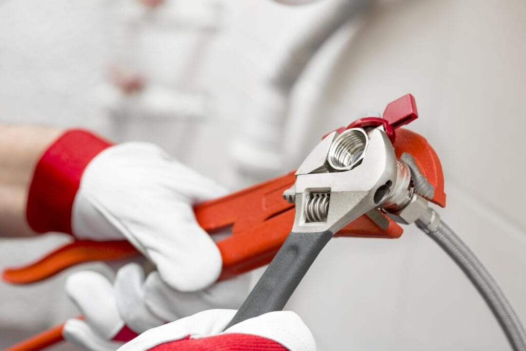 Plumber holding pipe wrenches for an emergency repair in Bartow