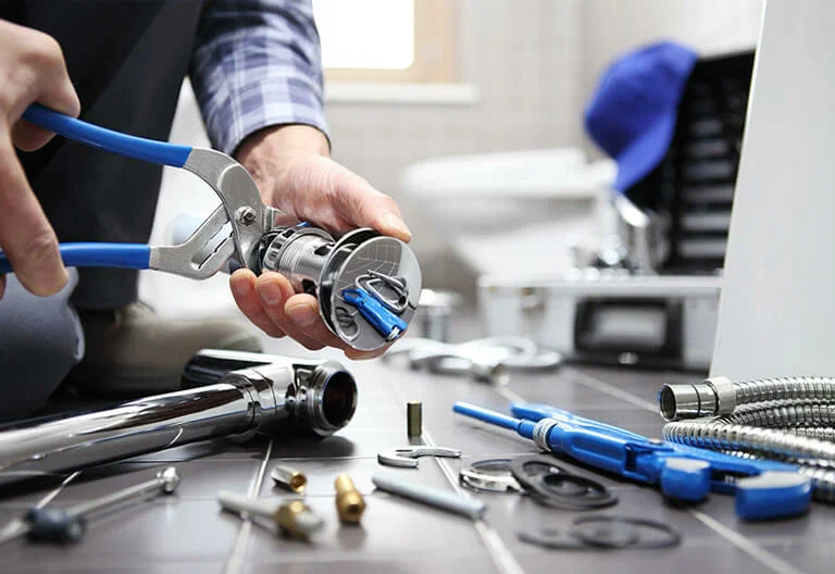 Technician repairing a plumbing fixture with professional tools in Bartow
