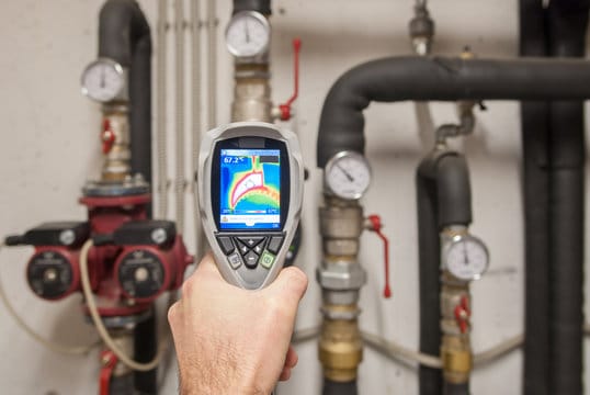 Plumber using a thermal imaging camera to inspect pipes in Bartow