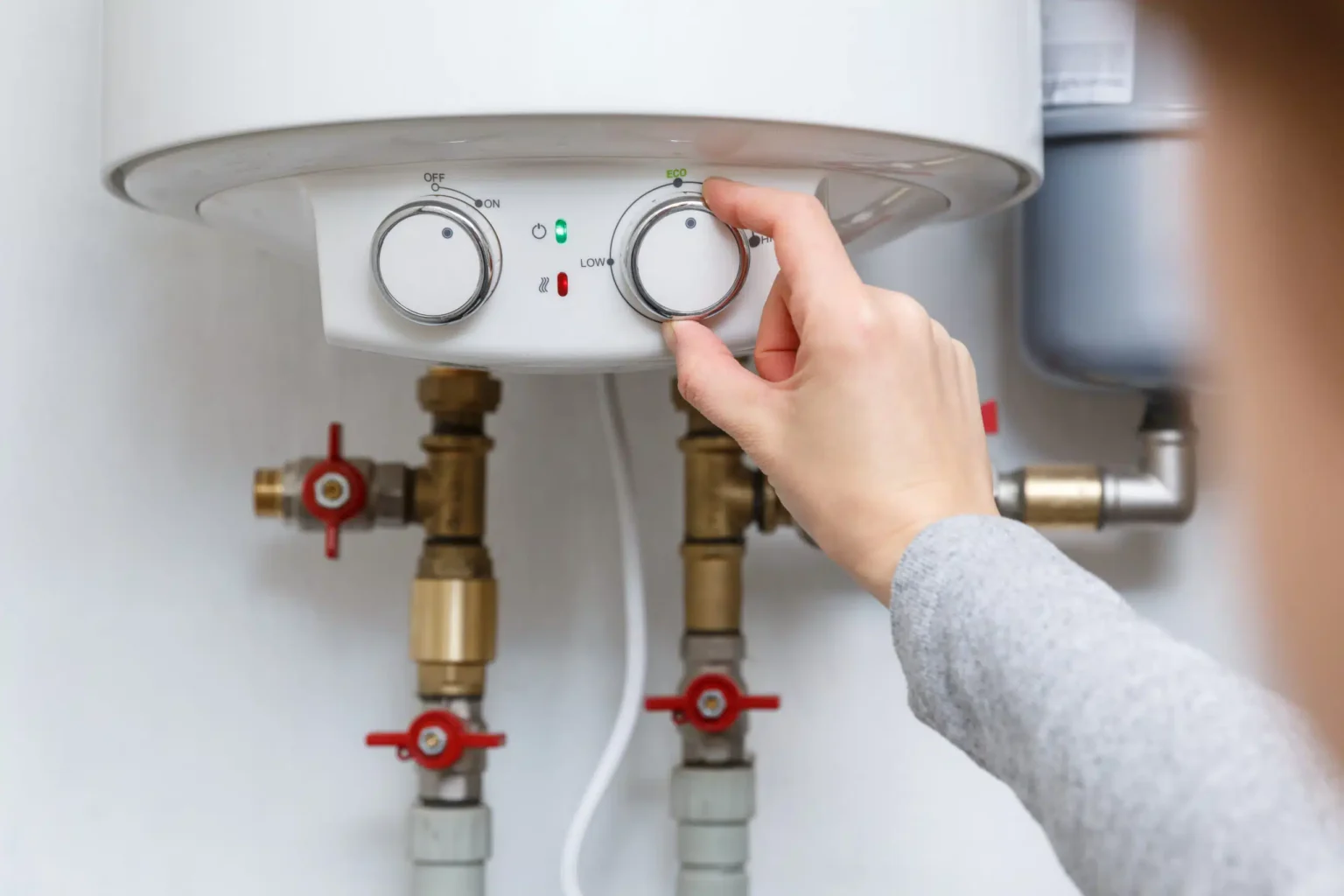 Homeowner adjusting the temperature controls on a water heater in Bartow